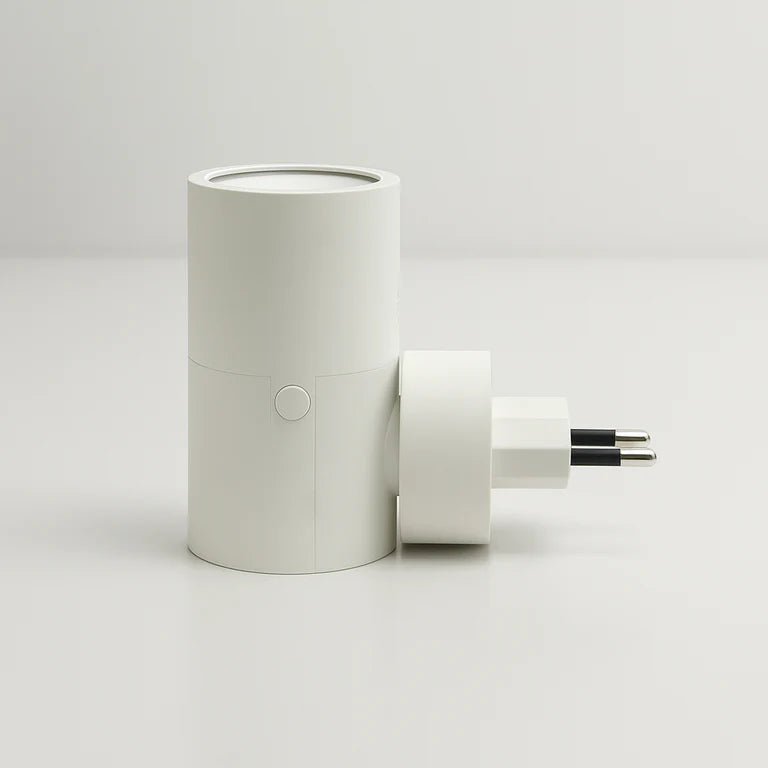 PLUGIFY One plug-in wall light in matte finish mounted in a bedroom wall socket, casting warm ambient light onto a wooden bedside table with a remote control and ceramic mug beside it.
